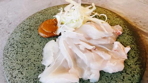 a plate of food with onions on a table at Marine Hotel Harimo in Hamada