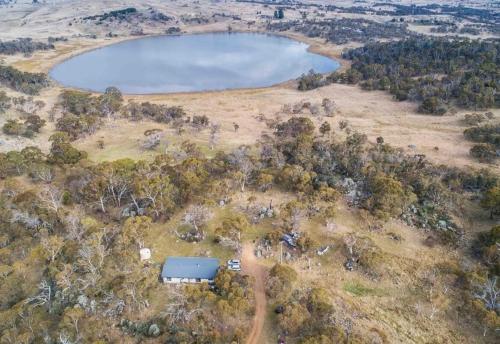 an aerial view of a field with a lake at Jillamatong House in Moonbah