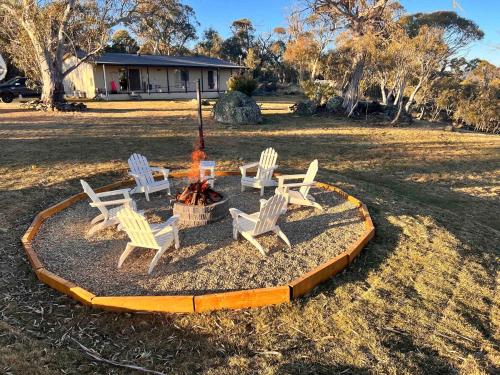 a group of chairs sitting around a fire pit at Jillamatong House in Moonbah