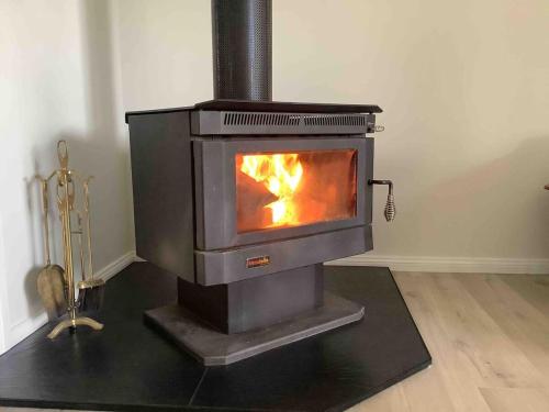a wood stove is sitting in a room at Jillamatong House in Moonbah