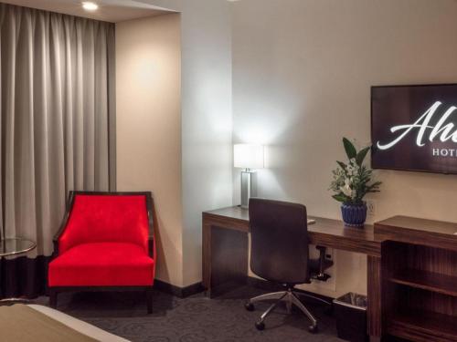 a room with a red chair and a desk at Ahern Hotel and Event Center in Las Vegas