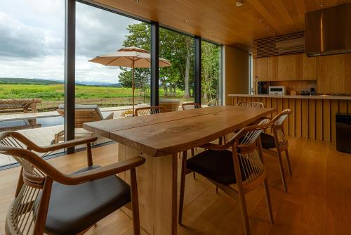 a kitchen and dining room with a wooden table and chairs at SONEKA in Kitahiroshima
