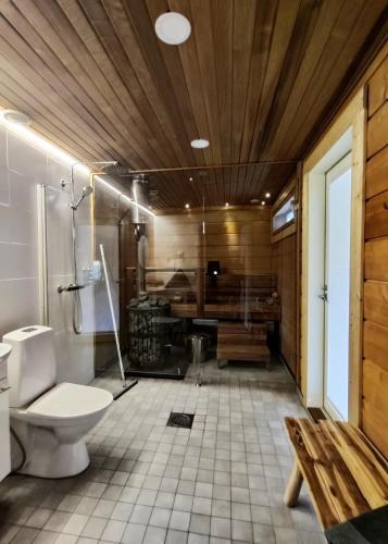 a bathroom with a toilet and a bath tub at Villa Huikonen in Syöte