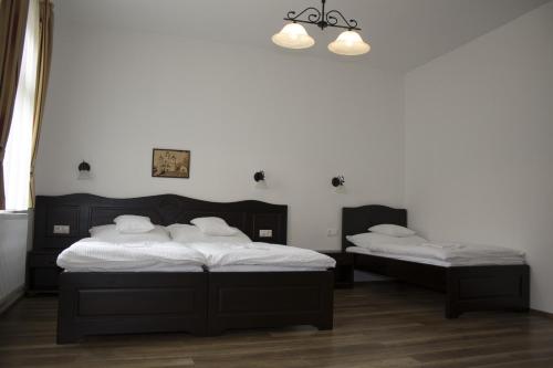 Pékapartman في كوسيغ: سريرين في غرفة بجدران بيضاء