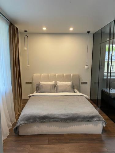 a bedroom with a large white bed with pillows at Centro apartamentai in Biržai