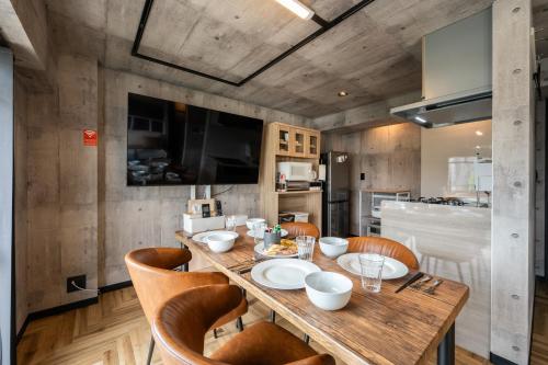 a dining room with a wooden table and chairs at Base605 in Kurume
