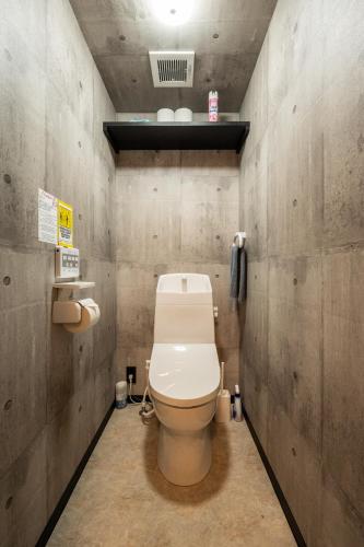 a bathroom with a white toilet in a room at Base605 in Kurume