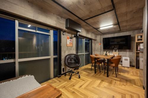 a room with a table and a chair and a desk at Base605 in Kurume