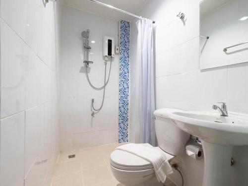 e bagno bianco con doccia, servizi igienici e lavandino. di B2 Phayao Boutique & Budget Hotel a Phayao