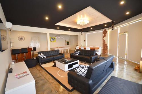 a living room with black leather furniture and a table at No.40 Echuca - Echuca Holiday Homes in Echuca