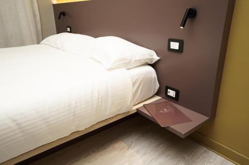 a bedroom with a white bed and a brown wall at Mario house Assisi in Assisi