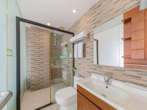 a bathroom with a shower and a toilet and a sink at GreenTree Alliance Hotel Shenzhen Yantian District Dameisha in Shenzhen