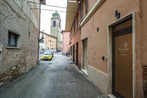 a yellow car driving down a street with a building at Mario house Assisi in Assisi
