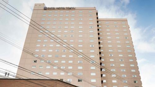 a tall brown building with a sign on it at Tokyu Vacations Sapporo in Sapporo