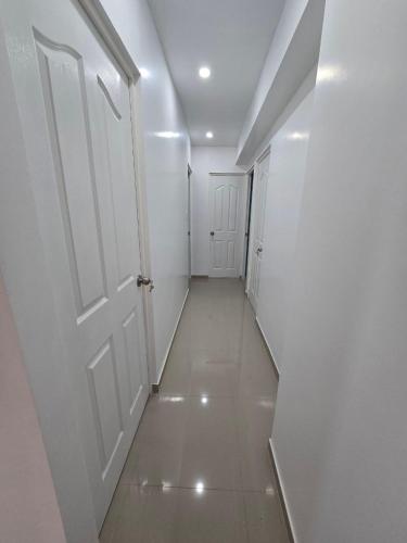 an empty hallway with two white doors and a tile floor at 501 Modern equipped department 3 in Abancay