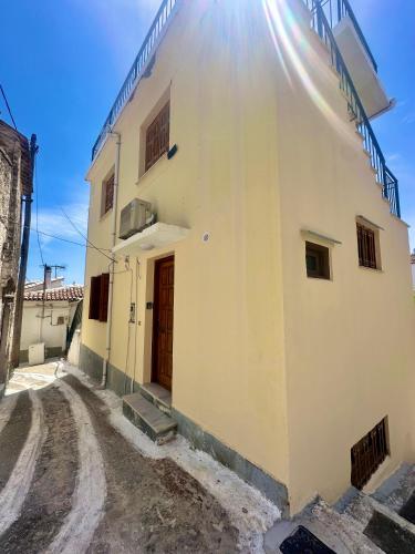 a white building with a door on a dirt road at MonJa puhkemaja in Marathokampos