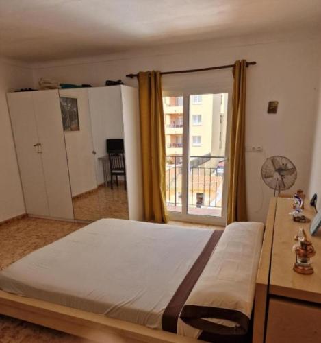 a bedroom with a bed and a large window at SunandSea in L'Estartit