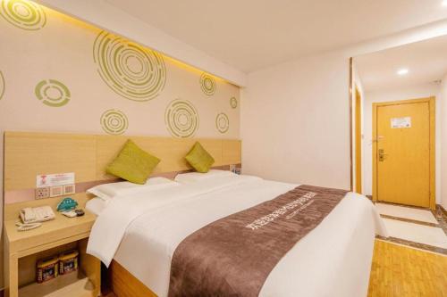 Ένα ή περισσότερα κρεβάτια σε δωμάτιο στο GreenTree Inn High-tech Zone Shandong University Bathing Beach Hotel
