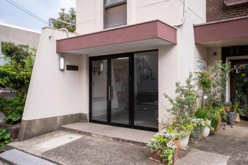 an entrance to a building with potted plants at Base605 in Kurume