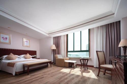 a hotel room with a bed and a desk at Sanya Baohong Hotel in Sanya