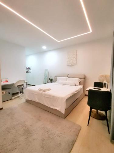 a bedroom with a bed and a desk and a chair at Three Homestay in Perai