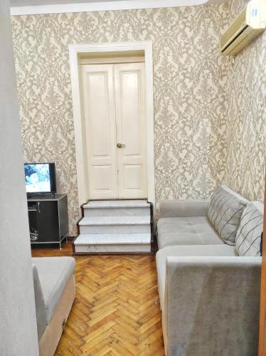 a living room with a couch and a white door at Sweet Home & Hostel in Baku