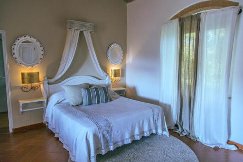 1 dormitorio con cama blanca y ventana en Fattoria di Fugnano, en San Gimignano