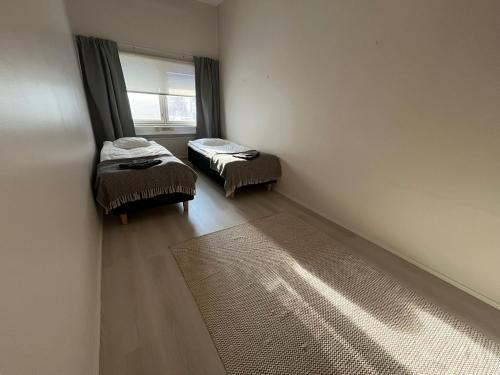 an empty room with two beds and a window at Luxury City Apartments, Korkalonkatu in Rovaniemi