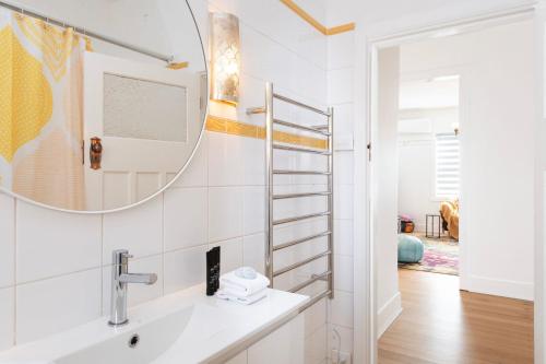 a bathroom with a sink and a mirror at Charming 3-Bedroom Retreat by St Kilda Gardens in Melbourne