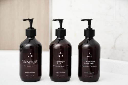 a group of three shampoo bottles sitting on a counter at RIHGA Royal Hotel Osaka, Vignette Collection by IHG in Osaka