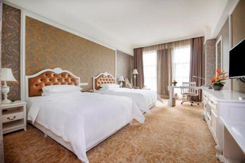 a bedroom with two beds and a flat screen tv at Chongqing Huachen International Hotel in Chongqing