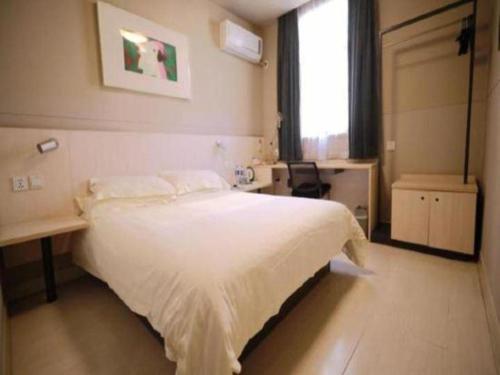 a bedroom with a large white bed and a window at Jinjiang Inn Nanjing Xinjiekou in Nanjing