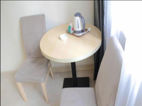 a small table and chair with a tea kettle on it at Jinjiang Inn Nanjing Xinjiekou in Nanjing