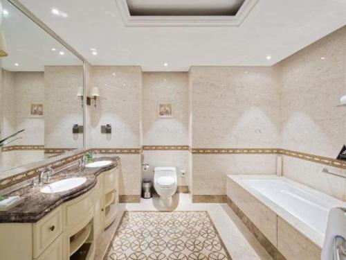 a bathroom with two sinks and a tub and a toilet at Yin Run Jin Jiang Castle Hotel in Huzhou