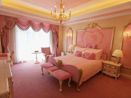 a pink bedroom with a large bed and a chandelier at Yin Run Jin Jiang Castle Hotel in Huzhou