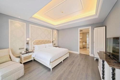 a bedroom with a bed and a couch and a tv at Yin Run Jin Jiang Castle Hotel in Huzhou
