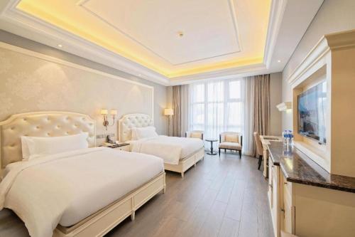 a hotel room with two beds and a television at Yin Run Jin Jiang Castle Hotel in Huzhou