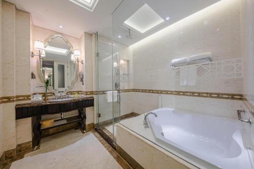 a bathroom with a large tub and a sink at Yin Run Jin Jiang Castle Hotel in Huzhou