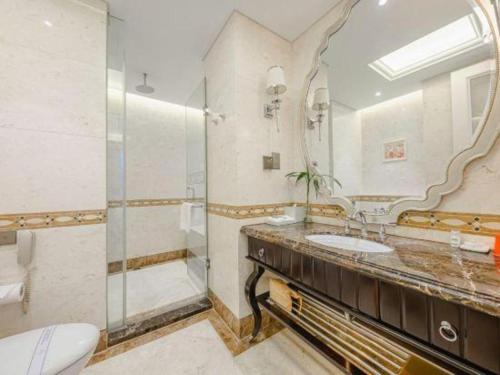 a bathroom with a sink and a shower and a mirror at Yin Run Jin Jiang Castle Hotel in Huzhou