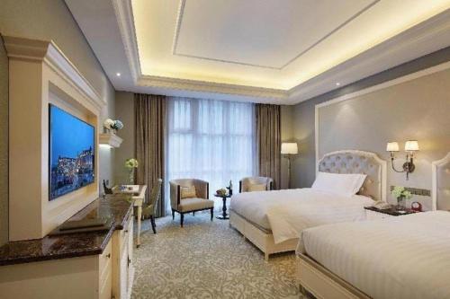 a hotel room with two beds and a large window at Yin Run Jin Jiang Castle Hotel in Huzhou