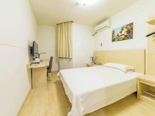 a bedroom with a large white bed and a desk at Magnotel Shanghai Henglong Plaza in Shanghai
