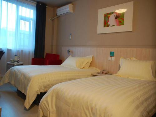 a hotel room with two beds and a window at Magnotel Shanghai Henglong Plaza in Shanghai
