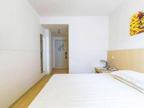 a bedroom with a white bed in a room at Magnotel Shanghai Henglong Plaza in Shanghai