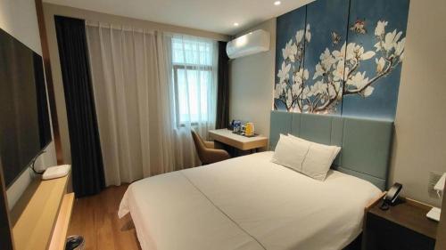 a hotel room with a white bed and a desk at Magnotel Shanghai Henglong Plaza in Shanghai