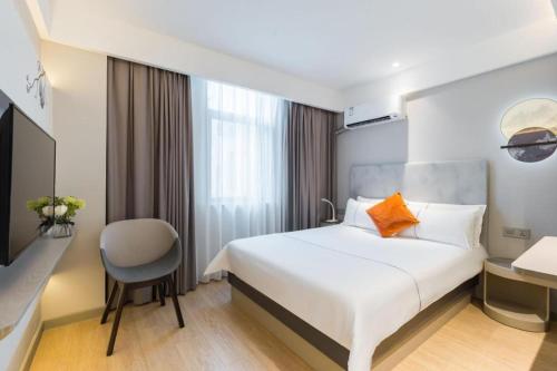a hotel room with a bed and a chair at Magnotel Shanghai Henglong Plaza in Shanghai