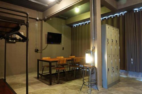 a conference room with a table and chairs and a television at Rider bedroom hostel & cafe in Hua Hin