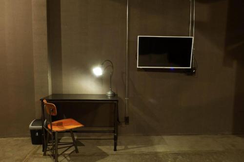 a desk with a lamp and a table with a chair at Rider bedroom hostel & cafe in Hua Hin