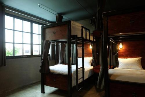 a bedroom with two bunk beds and a window at Rider bedroom hostel & cafe in Hua Hin
