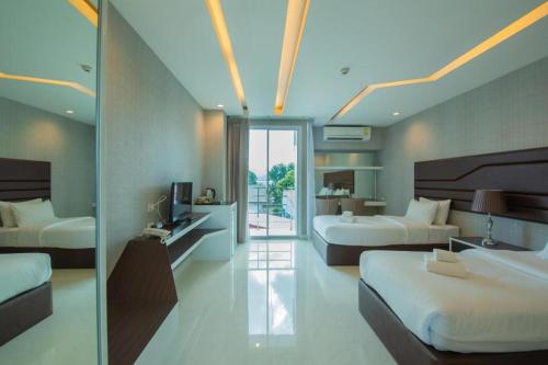 a hotel room with two beds and a balcony at Phuglong Hotel in Phayao