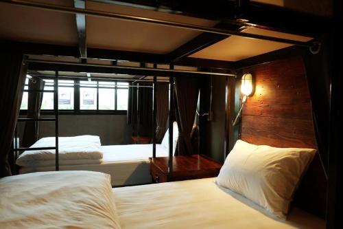 a bedroom with two bunk beds with white sheets at Rider bedroom hostel & cafe in Hua Hin